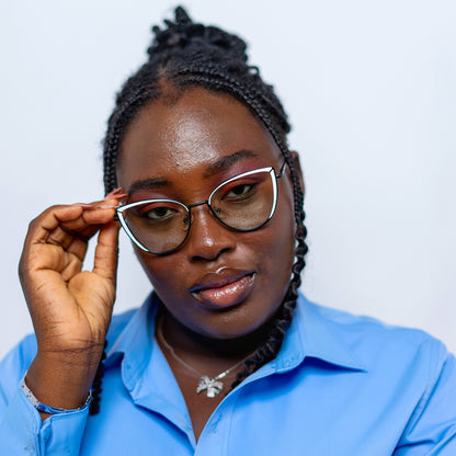 Person wearing peace glasses and a blue shirt against a plain background